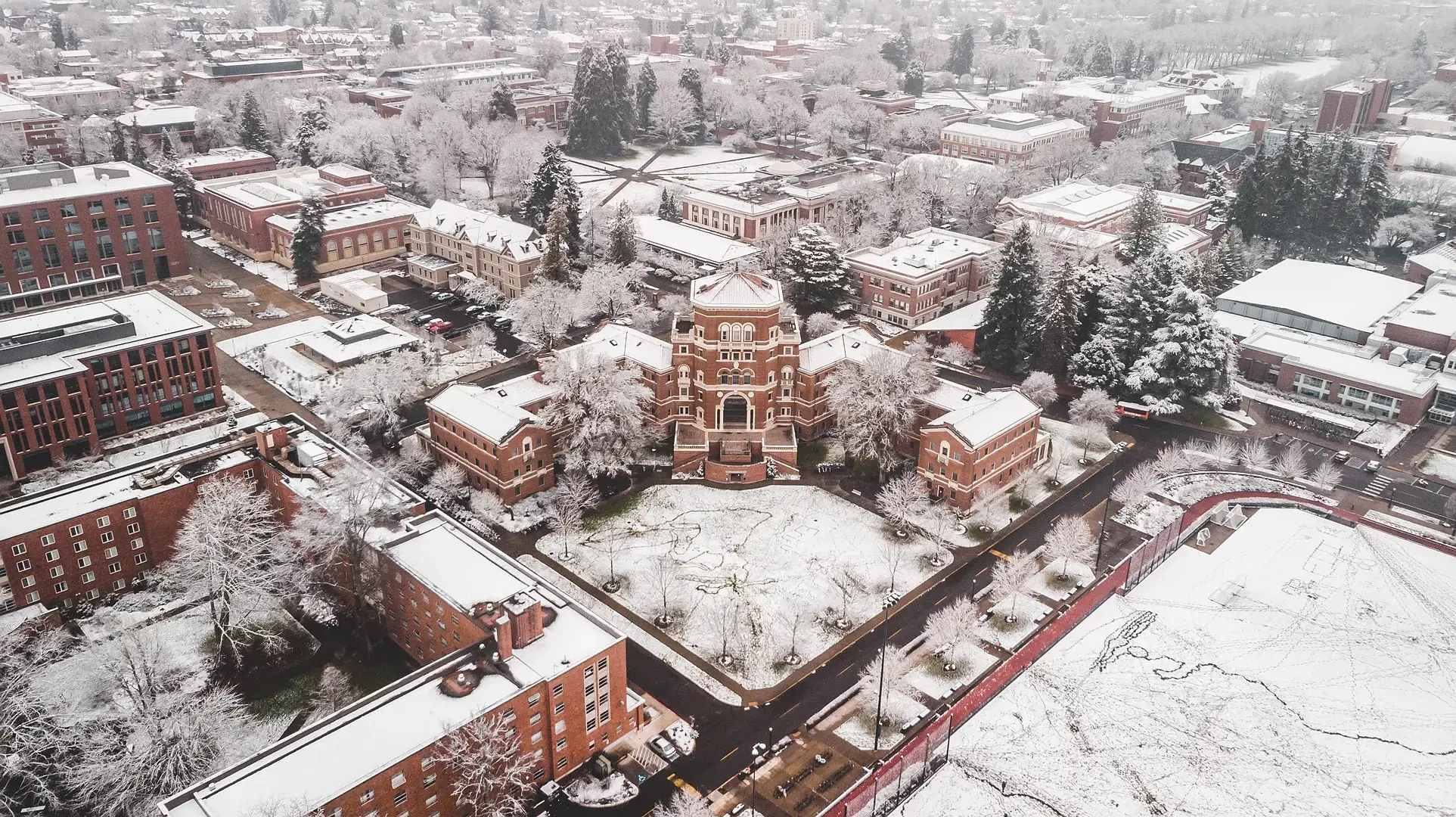 Snowy Oregon State campus with Weatherford Hall at the center.